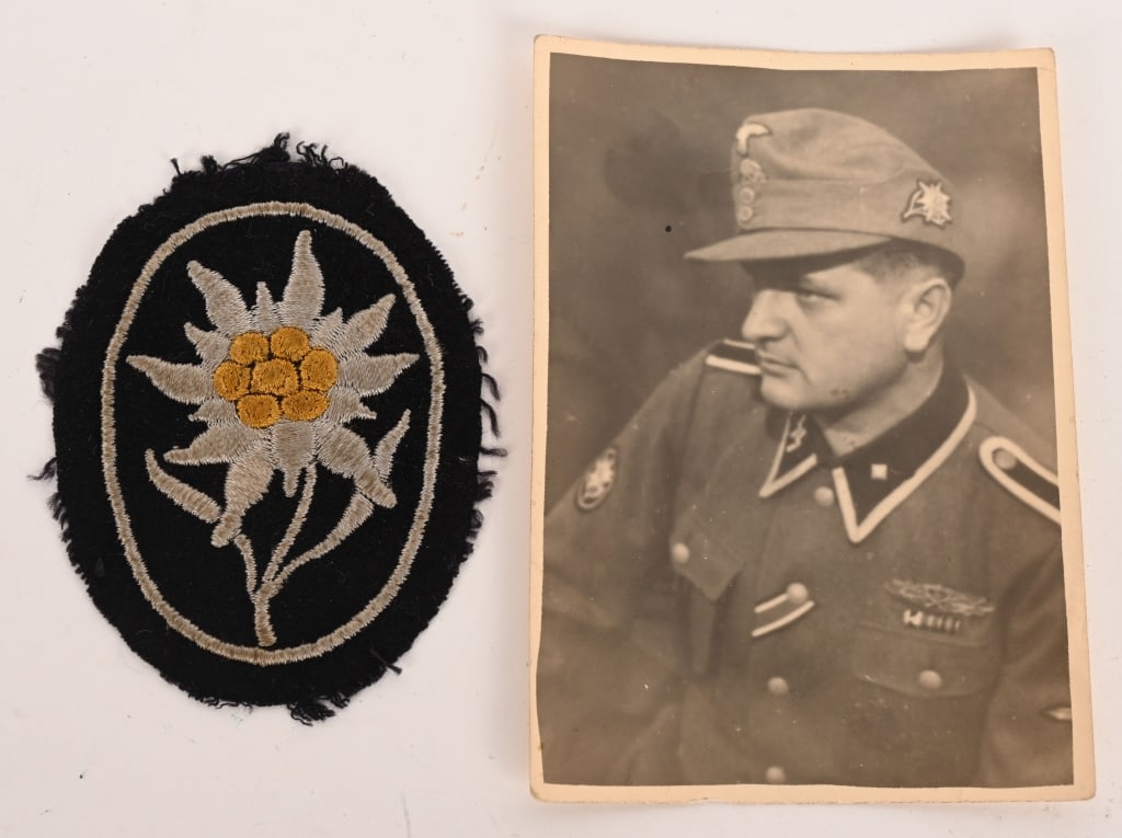 WWII WAFFEN SS LOT EDELWEISS & PHOTO WEARING IT: WWII Nazi German lot to include 1) WAFFEN SS MOUNTAIN TROOPS SLEEVE EDELWEISS. Black wool base with a machine embroidered Edelweiss with fourteen, irregular, silver/grey petals, a seven bulb, yellow s