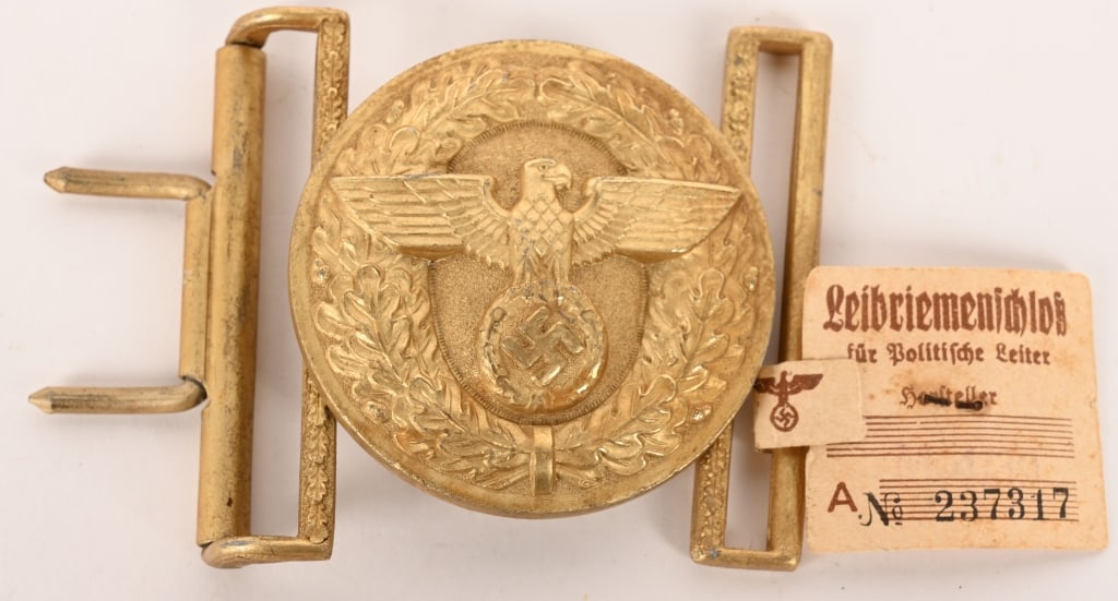 WWII NAZI NSDAP POLITICAL LEADER'S BELT BUCKLE TAG: WWII Nazi German NSDAP Political Officer;s Belt Buckle with RZM Paper Tag NSDAP POLITICAL LEADER'S BELT BUCKLE. A stamped, gold-washed aluminum belt buckle, whose convex obverse features a spread-wing