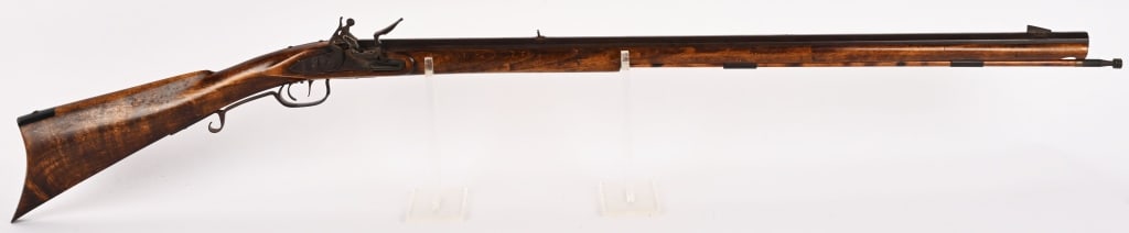 A BEAUTIFULLY WORKED MODERN FLINTLOCK .50 CAL: SERIAL NUMBER: NSN. BARREL: 33". CALIBER: .50. This is a great looking flintlock featuring a rich wood stock and ram rod and a rich deep plumb patina on metal parts. CONDITION: Very Good. The bore