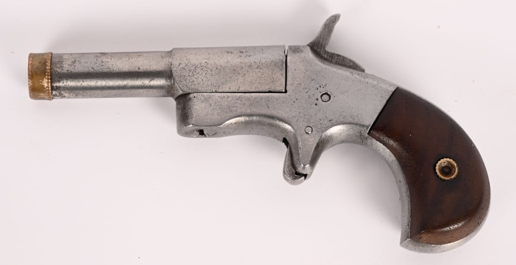 VEST POCKET .32 SINGLE SHOT DERRINGER: SERIAL NUMBER: 101. BARREL: 2 3/4". CALIBER: .32. This single shot derringer is a single shot miniature, extractor less side-swing pistol features birds head grips and a decorative muzzle ring.
