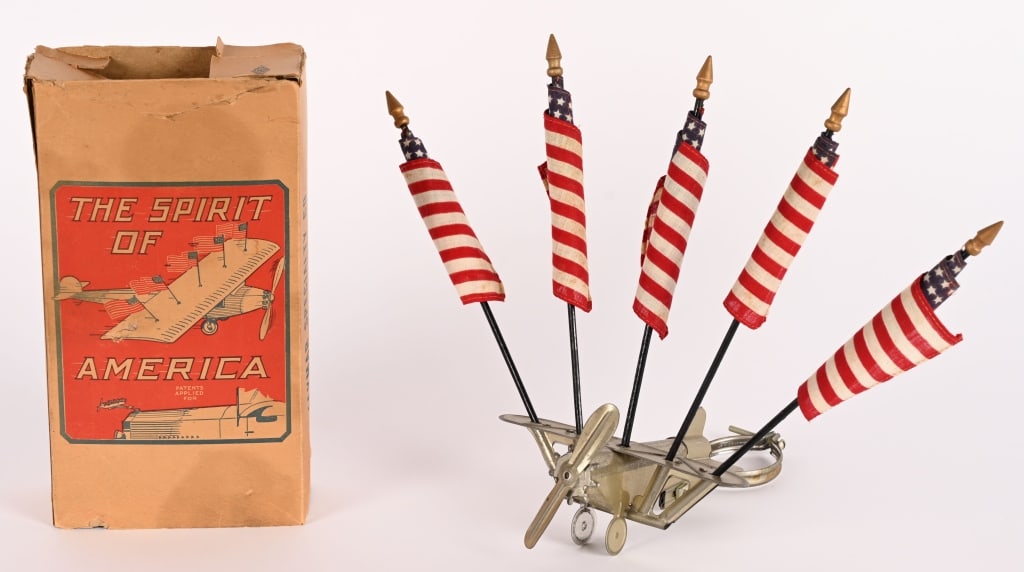 JAYMAR SPIRIT OF AMERICAN AIRPLANE HOOD ORNAMENT: Wonderful Jaymar Spirit of America Airplane Hood Ornament. Great looking tin Airplane with American Flags to be used as accessory car hood ornament. New Old Stock condition. Comes with Box. 11"
