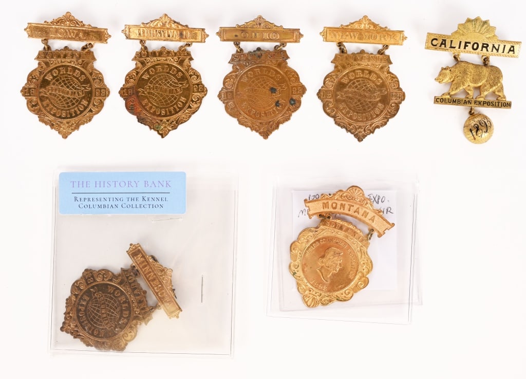 7 COLUMBIAN EXPOSITION STATE BADGES: Lot of 6 Columbian Exposition Gold Gilt State Badges. Includes California, New York, Minnesota, Ohio, Pennsylvania, Iowa, and Montana. All in great shape. Excellent