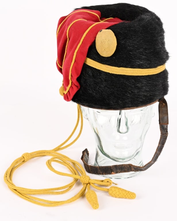 BRITISH 7TH HUSSARS 1858 PATTERN BUSBY & CAP LINES: British 7th (Queen’s Own) Hussars Busby affixed with cord and red fabric bag. Light wear but overall excellent condition. Body is made of bear skin.This appears to be a late Victorian era or pre