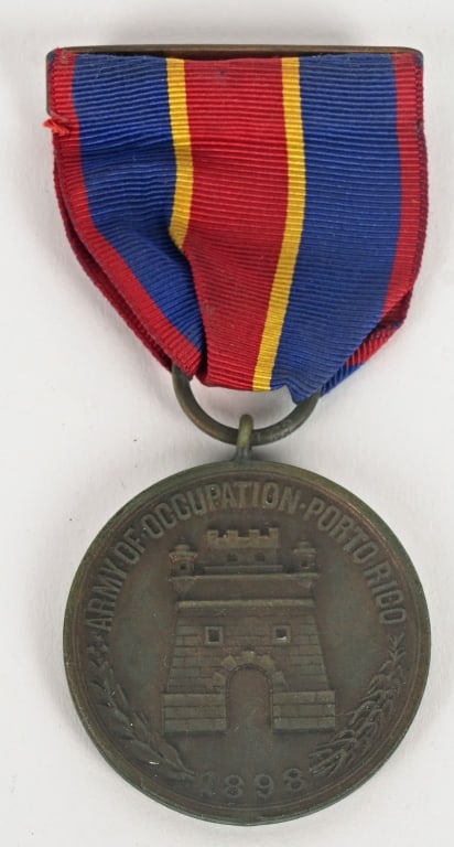 US ARMY PUERTO RICAN OCCUPATION MEDAL #1127: A circular bronze disc with an oxidized matte finish in relief, the obverse presents a castle in the centre with two small round towers at the corners, at the top is the inscription “ARMY OF OCC