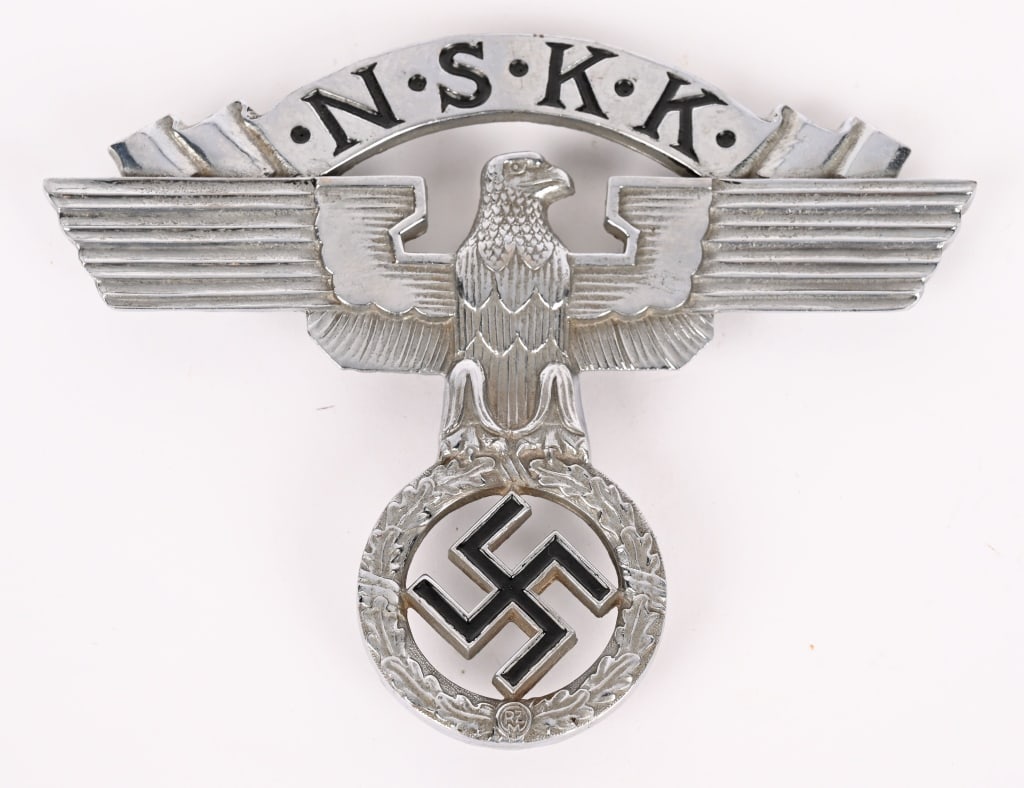 WWII NAZI GERMAN NSKK RADIATOR BADGE WW2: WWII Nazi German NSKK (National Socialist Motor Corps/Nationalsozialistisches Kraftfahrkorps) vehicle radiator plaque; in silvered bronze and black enamels; the obverse cast into the shape of the stan