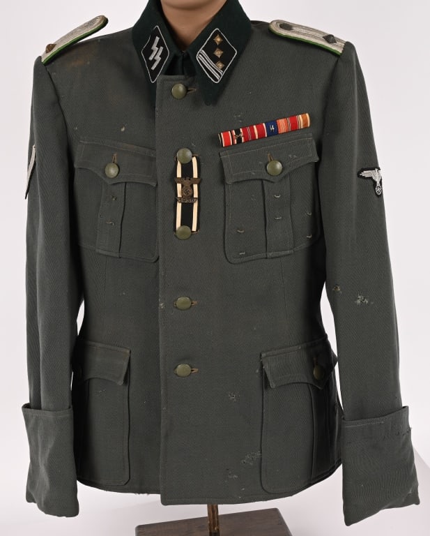 WWII NAZI GERMAN WAFFEN SS POLICE CAPTAIN'S TUNIC: Private purchase field-gray wool/rayon blend construction M36 pattern field blouse with a lay down, blue/green badge cloth collar, features a vertical, six button front closure with a double hook and 