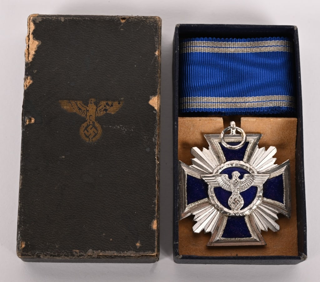 WWII NAZI NSDAP FIFTEEN YEAR LONG SERVICE MEDAL: Second class, two piece construction, die struck, alloy award, with a nickel/silver plating and royal blue enamel work. Award in the form of a cross Pattée with central circular centerpiece and s