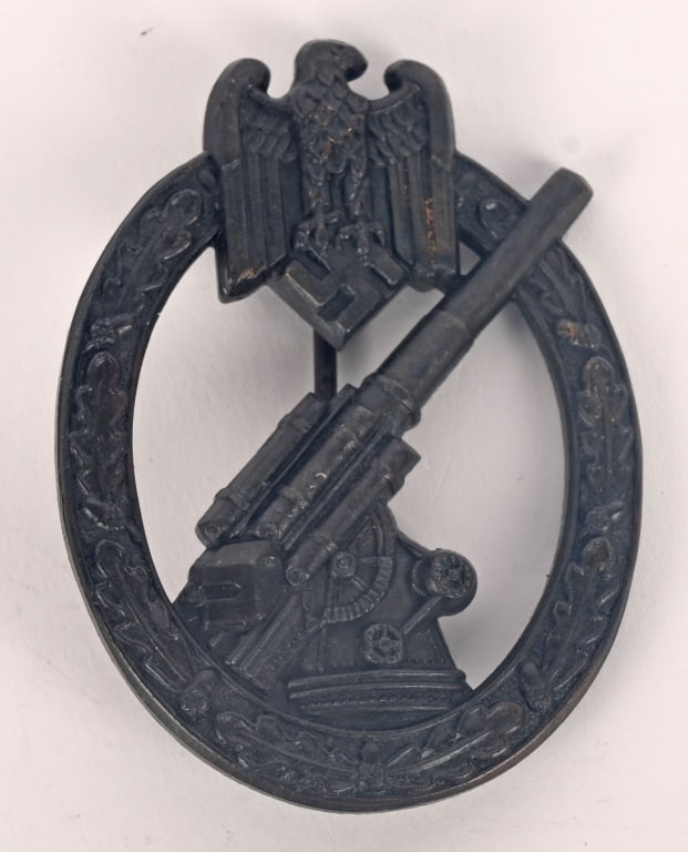 WWII NAZI GERMAN ARMY FLAK ARTILLERY BADGE WW2: (Flakkampfabzeichen des Heeres). Constructed of silvered tombac, the obverse consisting of an oval oak leaf wreath, topped by a Heer-style German national eagle clutching a mobile swastika, around a c