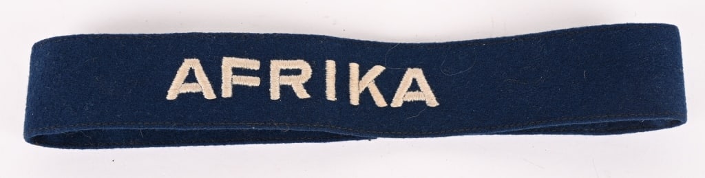 WWII NAZI GERMAN LUFTWAFFE AFRIKA CUFFTITLE WW2: Roughly, 32mm tall, 37cm long, deep navy blue wool construction, EM/NCO’s cufftitle with machine embroidered, block letter, Latin script, "AFRIKA" in light silvery/grey rayon threads. The cuffti
