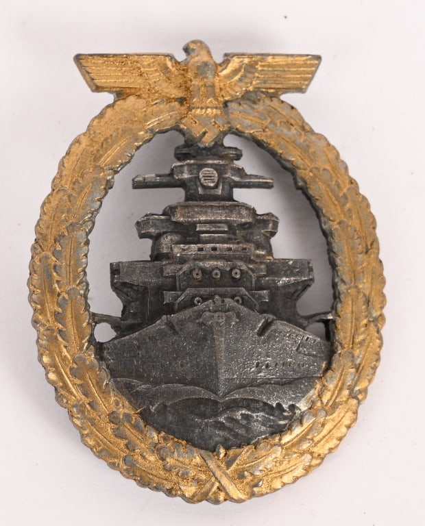 WWII NAZI GERMAN HIGH SEAS FLEET BADGE WW2: Die struck, solid backed, nicely convexed, alloy construction badge with gilt and burnished silver finishes. The badge features a vertically oval oak-leaf wreath with a national eagle with out-stretch