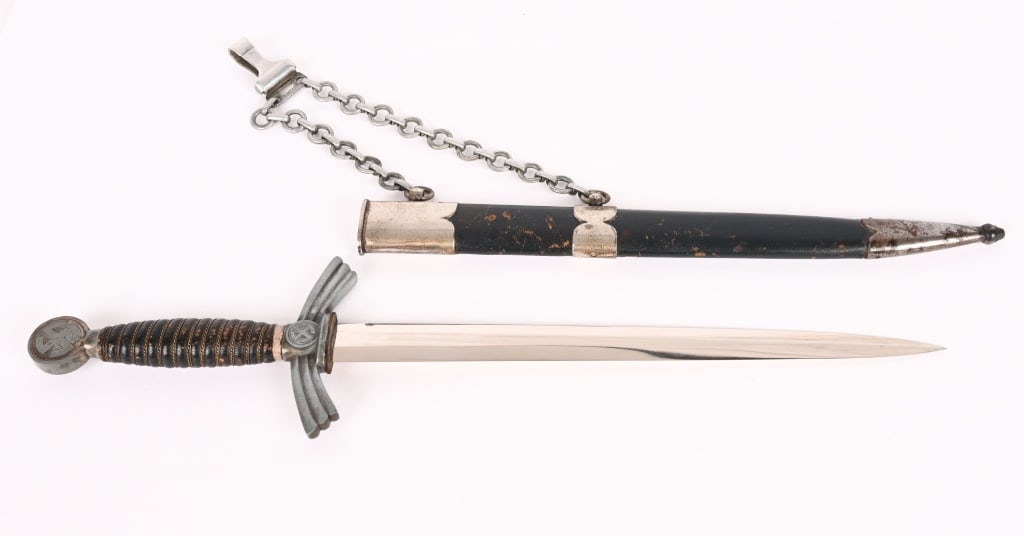 WWII NAZI GERMAN 1ST MOD. LUFTWAFFE DAGGER WW2: 1st Model (1934/35) Luftwaffe dagger and hanger with plated nickle silver crossguard, pommel, and scabbard fittings. Blade is unmarked. Leather grip has minor wear with all wire wrap tight. Blade has 