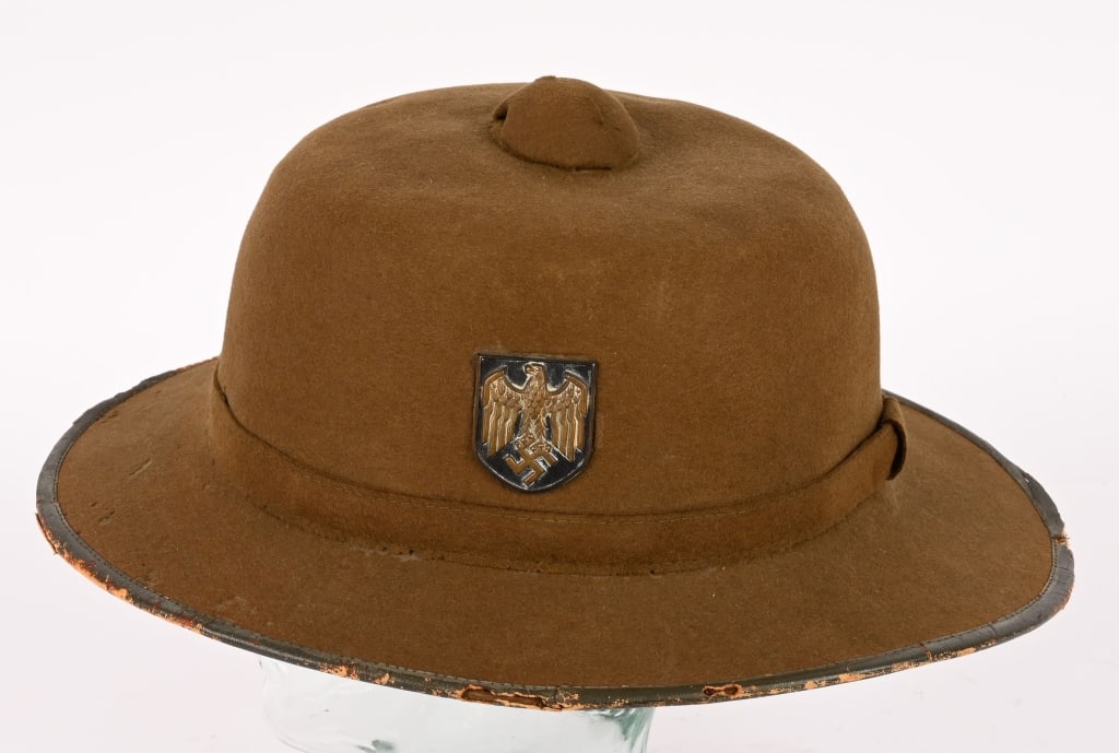 WWII NAZI WEHRMACHT GERMAN TROPICAL PITH HELMET: Second pattern pith helmet constructed in a one piece seamless formed olive-drab felt crown with a horizontal band stitched at the rear center and covered by a vertical strip of felt mounted on a form