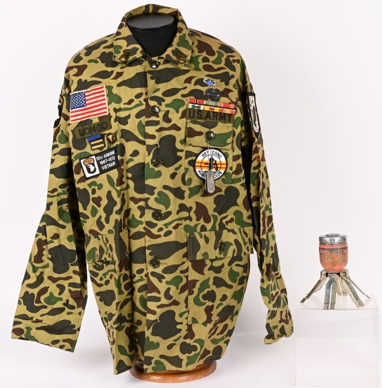 VIETNAM VETERANS 101ST AIRBORNE DUCK CAMO SHIRT: Vietnam Veterans Duck Camo Shirt size marked XL. The shirt is adorned with Dog Tags of Longo Emerson J. RA 12 712 672 O NONE. 6 place Ribbon Bar to include Bronze Star, Army Commendation Medal, Good C