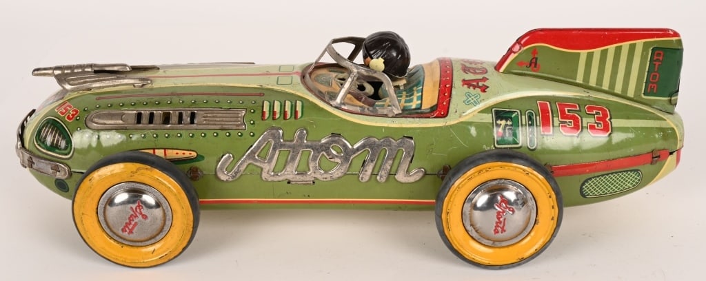 JAPAN TIN FRICTION ATOM RACE CAR: Great looking Futuristic Race Car. Has nice colors. Head is replaced and not attached. Friction works. A very desirable toy. 15 1/2" Excellent
