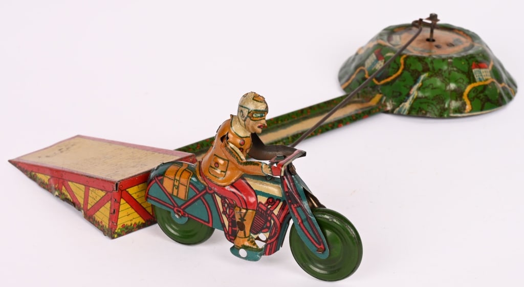 GERMAN WINDUP MOTORCYCLE GO-ROUND: All original with great colors and graphics. Windup works and motorcycle rides in circle and jumps the ramp. Very nice toy. 12" Excellent