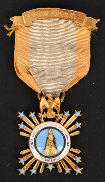 SOCIETY OF THE COLONIAL DAMES MEDAL IN GOLD NAMED: In 14K Gold with light blue and white enamels, weighing 15.9 grams inclusive of its ribbon and pinback, maker marked "BAILEY BANKS & BIDDLE PHILA", marked "PAT." (Patent) on the reverse of the eagle,