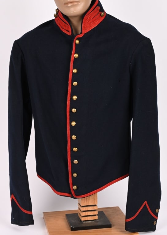 CIVIL WAR FEDERAL FIELD ARTILLERY SHELL JACKET: Standard issue dark blue wool shell jacket with red piping on collar and cuffs with red trim down the front and along the edges. Jacket has 12 General Service eagle buttons down the front with two but