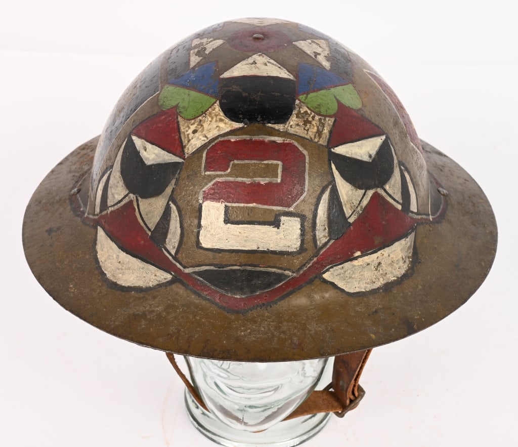 WW1 TOP SHELF PAINTED RIMLESS BRODIE HELMET WWI: A very unusual British Made Rimless Brodie helmet with a geometric design with 1st Division, 1st Army, 2nd Army and 5tth Division painted insignia. Helmet is complete with liner and chinstrap. Ex