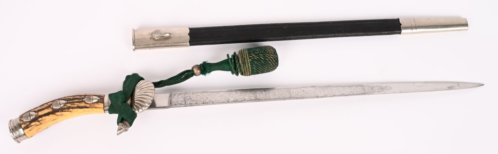 WWI IMPERIAL GERMAN PRESENTATION HUNTING CUTLASS: All of the mounts are in beautiful silver and they have patinated very nicely throughout the areas although some of the frosting remains where they are brighter. The pommel cap is a fine example