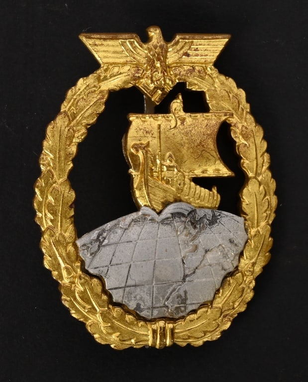 WWII NAZI GERMAN AUXILIARY CRUISER WAR BADGE WW2: Two piece, die struck, tombak construction badge with fire gilt and nickel/silver plated finishes that is completely gone giving it a gray look . The badge is in the form a gilt washed, vertically ova