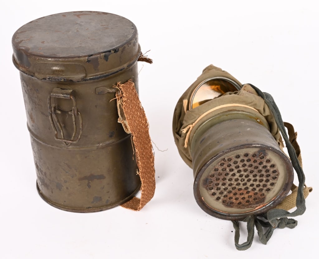 WW1 IMPERIAL GERMAN M1915 GASMASK & CANISTER WWI: The Gummimaske M15 is made of impermeable rubberized cotton fabric. The stamped round metal frames in eye glasses are made of non-combustible celluloid. The mask is held on the head by two elastic ban