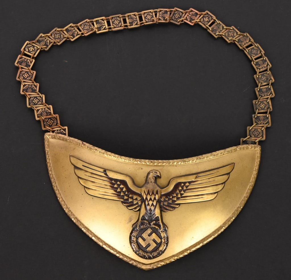 WWII NSDAP POLITICAL LEADER FLAG BEARER'S GORGET: Stamped alloy gorget with a bronze wash. The half-moon shaped gorget measures roughly, 24cm wide from upper tip to tip and 12cm tall. The gorget features a separate, stylized, bronze washed, embossed 