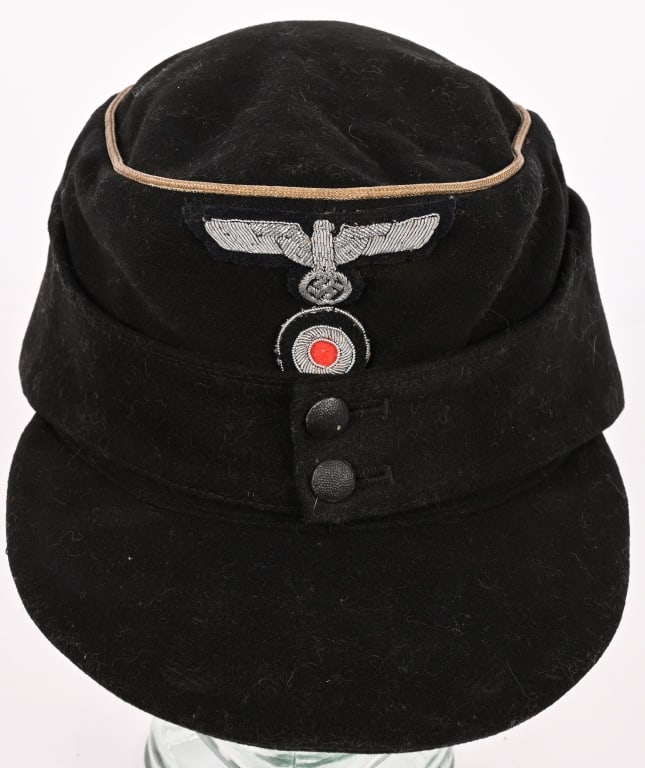 WWII NAZI GERMAN PANZER OFFICERS M43 CAP SIZE 57: Black wool/rayon blend construction cap features fold down back and side panels with a downward scalloped front edge and forward sides and two metallic pebbled buttons to the front center. The buttons