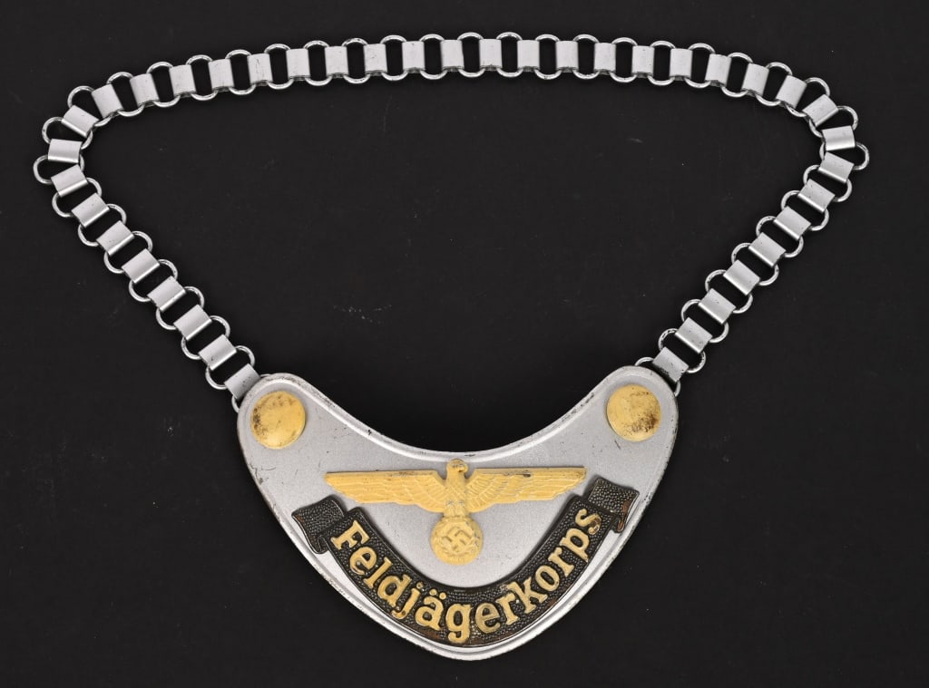WWII NAZI GERMAN WEHRMACHT FELDJÄGERKORPS GORGET: (Wehrmacht Ringkragen der Feldjägerkorps). Constructed of magnetic metal with a matte silver base paint, the obverse bearing a central raised Wehrmacht eagle clutching a wreathed mobile swastika,