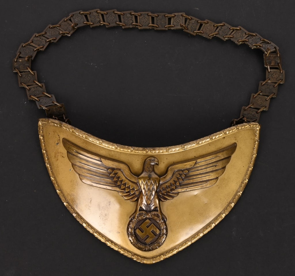 WWII NSDAP POLITICAL LEADER FLAG BEARER'S GORGET: Stamped alloy gorget with a bronze wash. The half-moon shaped gorget measures roughly, 24cm wide from upper tip to tip and 12cm tall. The gorget features a separate, stylized, bronze washed, embossed