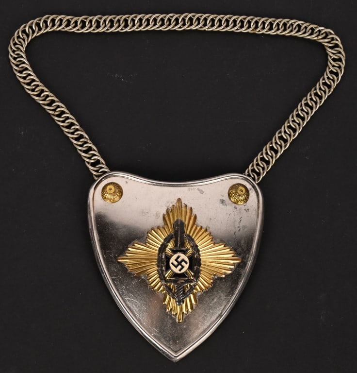 WWII NAZI GERMAN NSKOV GORGET WITH CHAIN WW2: NSKOV gorget is made of lightweight metal, nickel plated. It measures about 4-3/4” across and 5-1/4” high. The heart-shaped backing plate features a separate gilt sunburst emblem, on top o