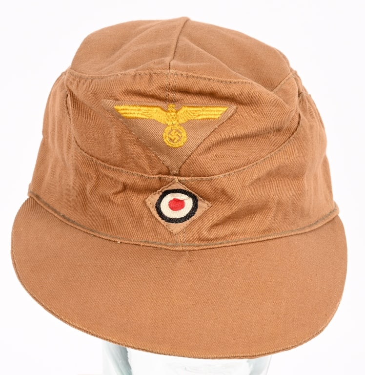 WWII NAZI GERMAN COASTAL ART TROPICAL FIELD CAP: Tan, cotton/rayon blend construction cap features gently sloping stitched down side panels with a scalloped front. The cap has two, large, olive drab painted, metal alloy ventilation grommets to each 