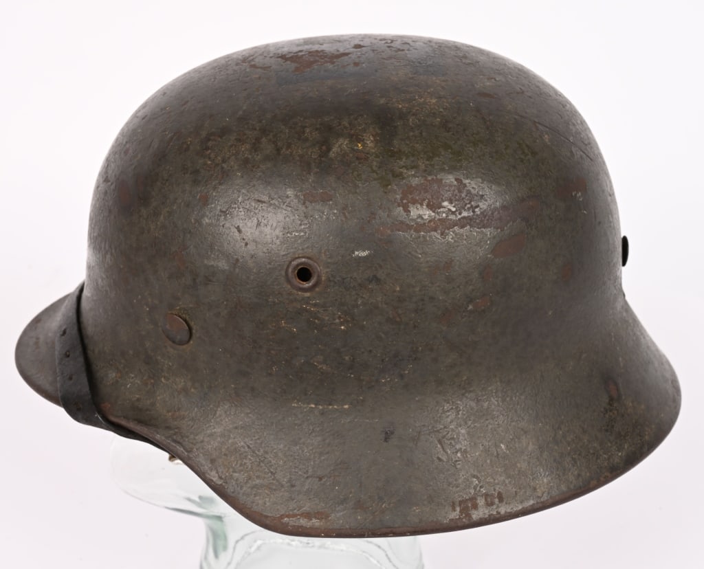WWII NAZI GERMAN HEER M40 COMBAT HELMET NS64: The stamped, sheet steel construction helmet retains about 85% of its factory applied field-gray paint. The GI who brought the helmet back has painted a large black Swastika to the top of the lid. All