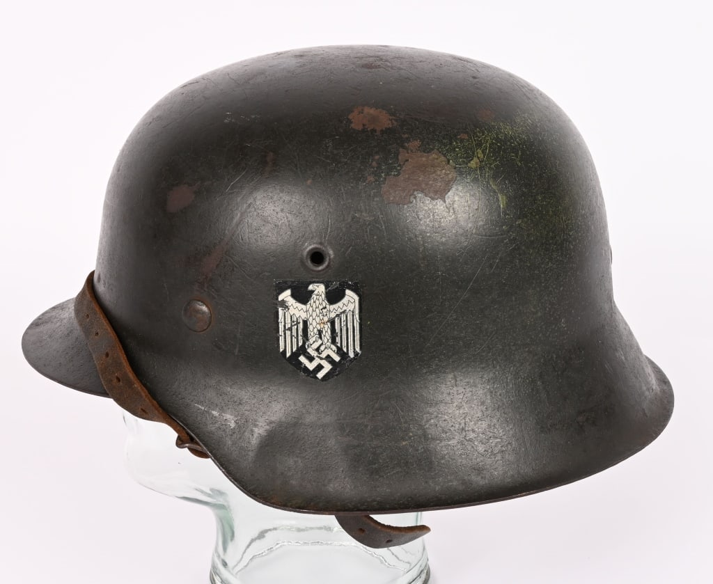 WWII NAZI GERMAN M42 ARMY COMBAT HELMET W/ LINER: The stamped sheet steel construction helmet retains about 95% of its factory applied field-gray paint. The left side of the helmet has an Wehrmacht eagle shield decal featuring a eagle with down-swept