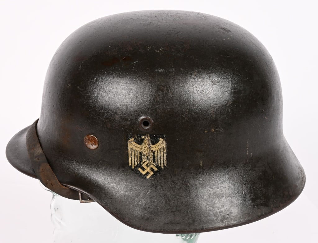 WWII NAZI GERMAN M40 EF64 SD HEER HELMET W LINER: The stamped, sheet steel construction helmet retains most of its field-gray paint. The left side of the helmet has a Wehrmacht eagle shield decal which is retained about 95%. All three liner retaining