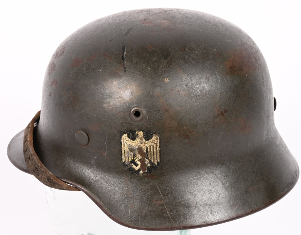 WWII NAZI GERMAN M42 SINGLE DECAL HELMET ET62 WW2: The stamped, sheet steel construction helmet retains most of its factory applied field-gray paint. The left side of the helmet has an Wehrmacht eagle shield decal featuring a eagle with down-swept win