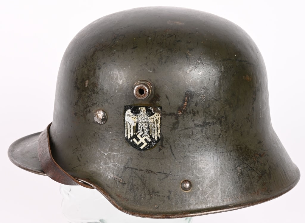WWII NAZI GERMAN SD M18 TRANSITION HELMET WW2: The stamped sheet steel construction M18 helmet retains most of its green, transitional over-paint. The left side of the helmet has an Wehrmacht eagle decal which is retained about 80%. The helmet has