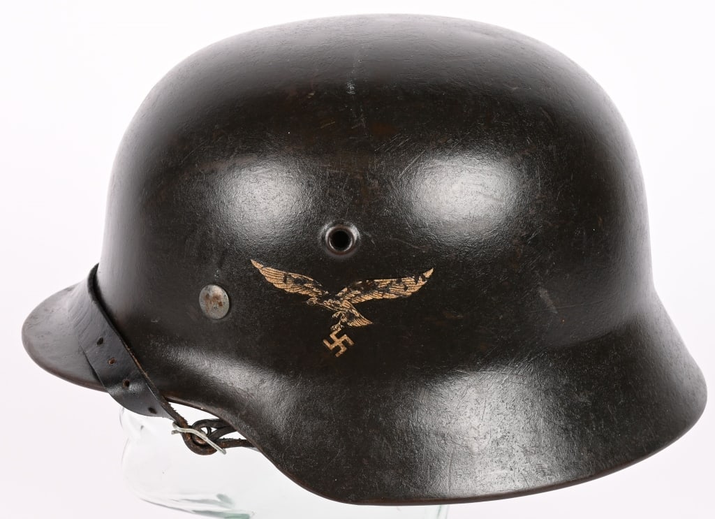 WWII NAZI GERMAN LUFTWAFFE M40 SINGLE DECAL HELMET: The stamped, sheet steel construction helmet retains most of its original rough textured paint. The left side of the helmet has a second pattern, (Circa 1936/1937-1945), black detailed, silvery/white,