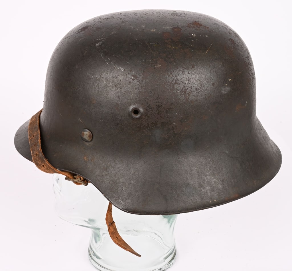 WWII NAZI GERMAN M42 COMBAT HELMET ET64 WW2: The stamped, sheet steel construction helmet retains most of its factory applied field-gray paint. All three liner retaining rivets are all intact. The interior of the helmet has a M31, tan, leather l