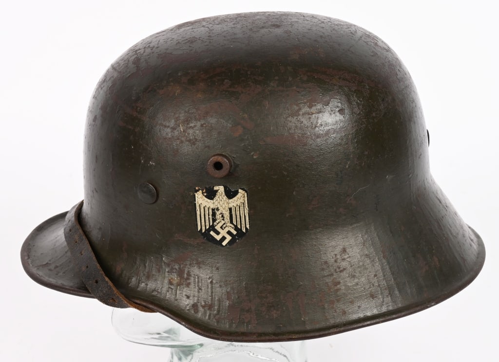 WWII NAZI GERMAN SD M16 TRANSITION HELMET WW2: The stamped sheet steel construction M16 helmet retains almost 85% of its green, transitional over-paint. The left side of the helmet has an Wehrmacht eagle decal which is retained about 95%. The helm