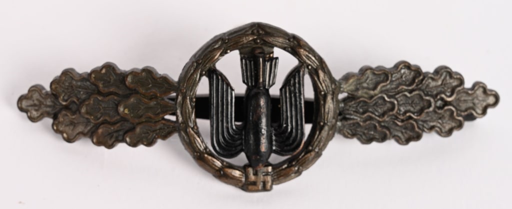 WWII NAZI LUFTWAFFE DIVE BOMBERS SQUADRON CLASP: Die struck two piece, zink construction clasp with a bronze finish. The clasp is in the form of a central circular embossed laurel leaf wreath with a static swastika superimposed to the bottom center 
