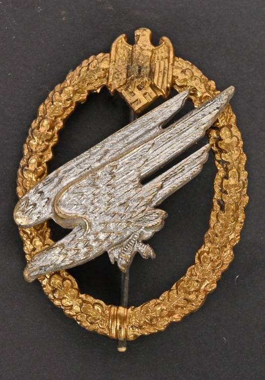 WWII NAZI GERMAN ARMY PARATROOPER'S BADGE WW2: Two piece, die struck alloy construction badge with gilted and silver washed finishes. The badge is in the form of a vertically oval, oak-leaf wreath with a small Wehrmacht style eagle with down swept