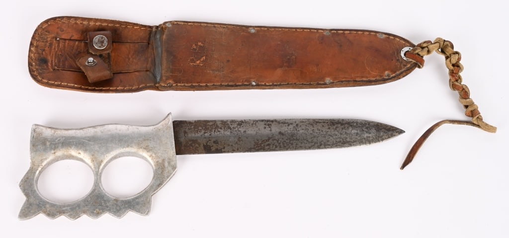 WWII AUSTRALIAN THEATER MADE KNUCKLE KNIFE WW2: Beautiful Theater Made Knuckle Knife measuring 12 1/2 inches with a 673/4 inch double edged blade. Comes with its original leather scabbard that is identified to a member of the 3rd Marine Division