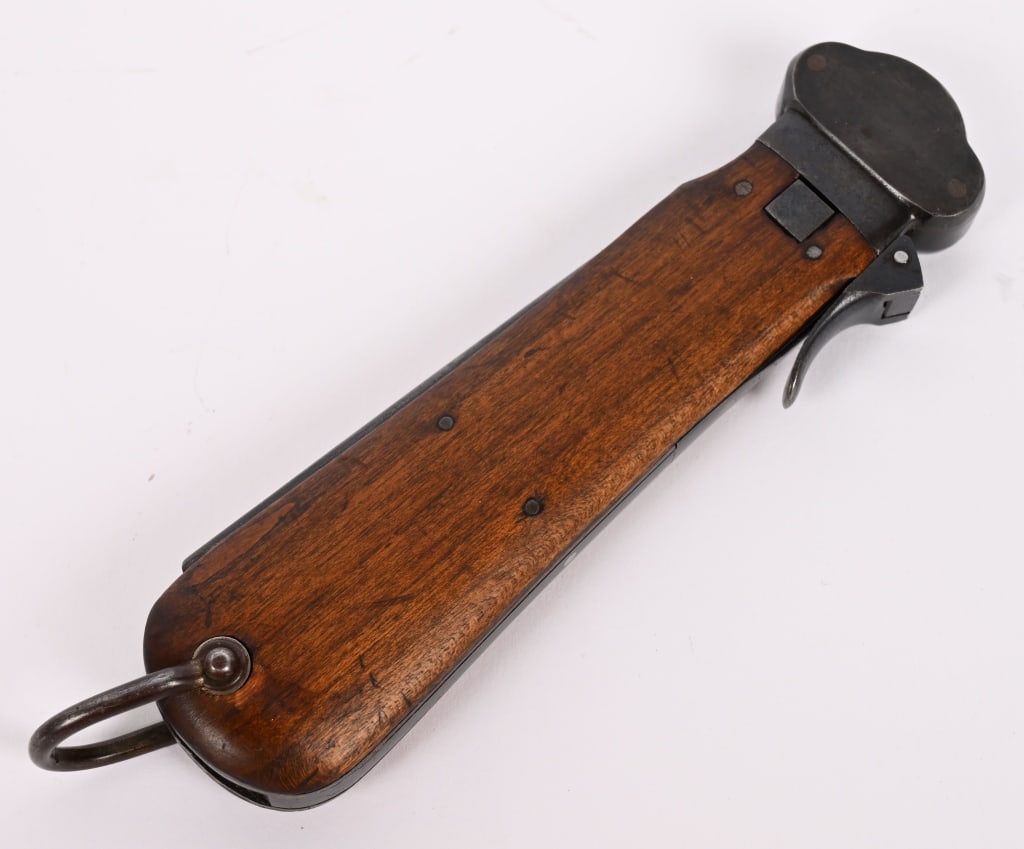 WWII NAZI GERMAN FALLSCHIRMJÄGER GRAVITY KNIFE WW2: A Luftwaffe paratrooper knife using a sliding steel blade inside a metal grip fitted with walnut, the grain running through vertically, grip plates. The blade is a relatively blunt spear-point with a