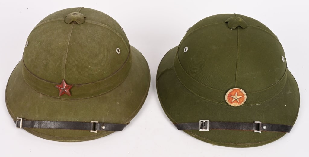 VIETNAM NORTH VIETNAMESE PITH HELMET LOT OF 2: North Vietnamese pith helmet, a lot of two helmets with plastic straps, cord crown, and green cloth covers. These helmets feature the North Vietnamese Army badge, featuring a five-pointed star. Some