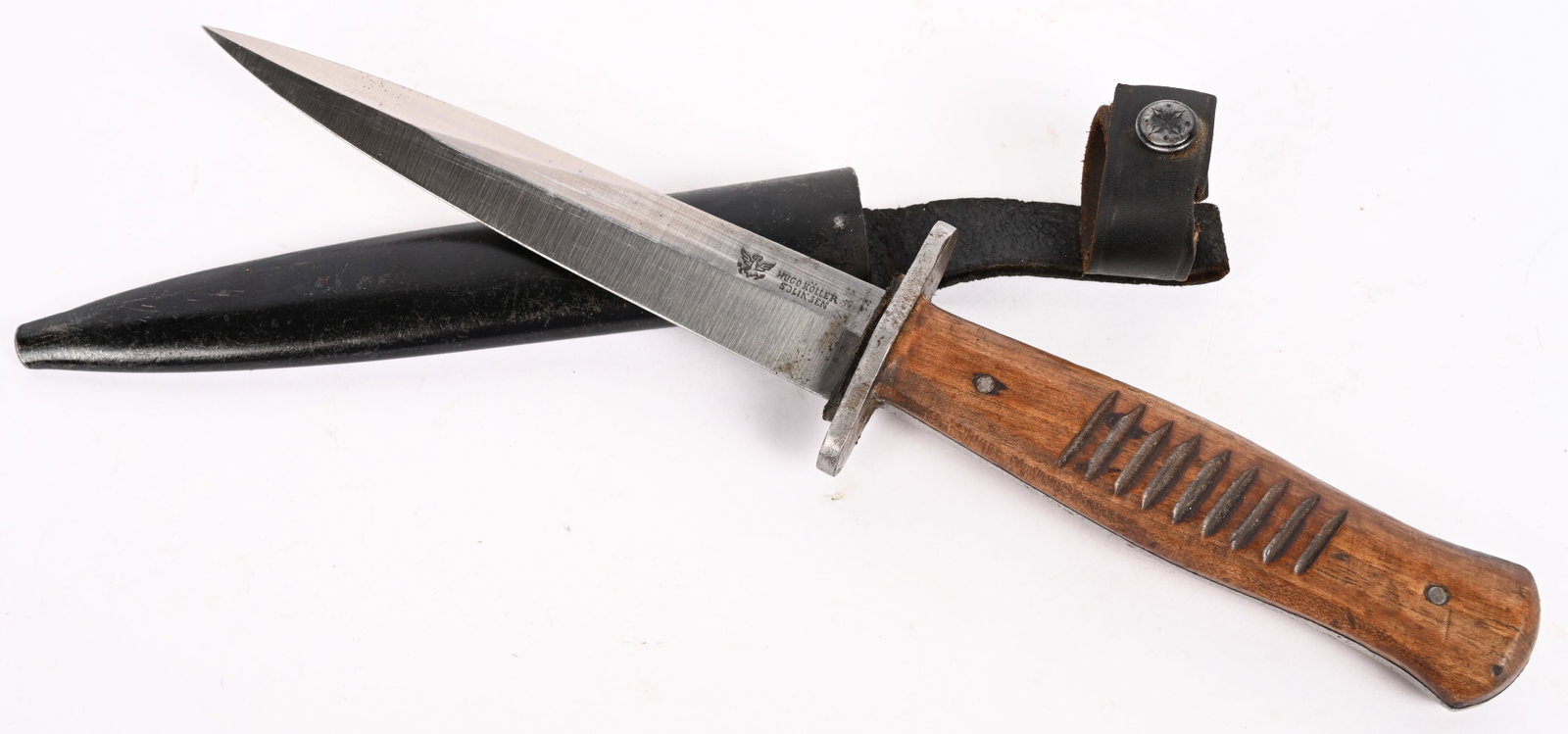 WW1 IMPERIAL GERMAN CLOSE COMBAT TRENCH KNIFE WWI: A trench knife with its original metal scabbard and integral, leather belt loop. The 14.5cm blade is in excellent clean untouched condition and is marked Hugo Köller Solingen. The natural wooden grip