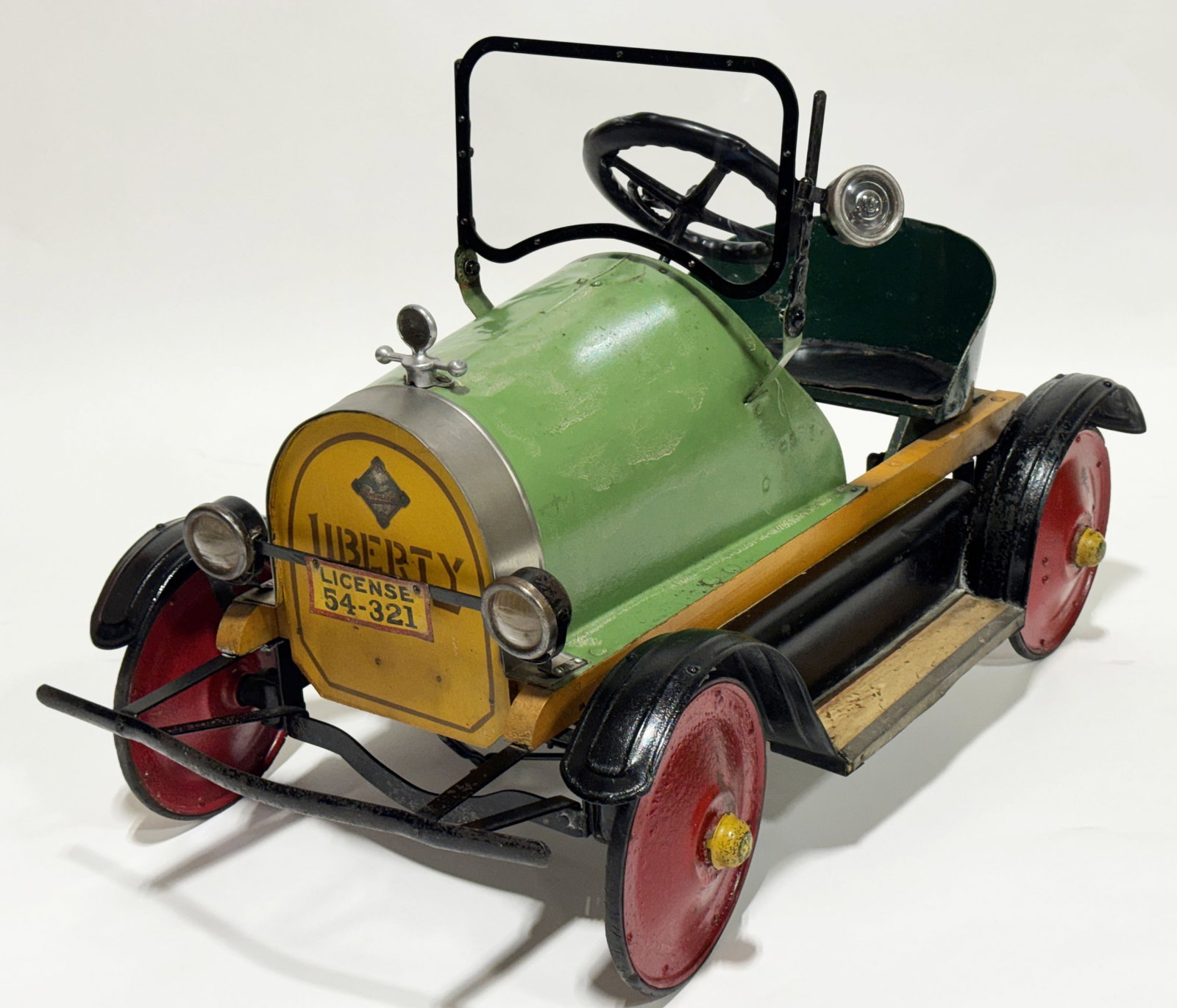 1920s AMERICAN NATIONAL LIBERTY PEDAL CAR: 1920s American National Pedal Car. Very nice pedal car with original Liberty Grill Insert. Car is a period repaint that has great patina. Car has accessory Spot Light, Hood Ornament, Dash, and Headlig