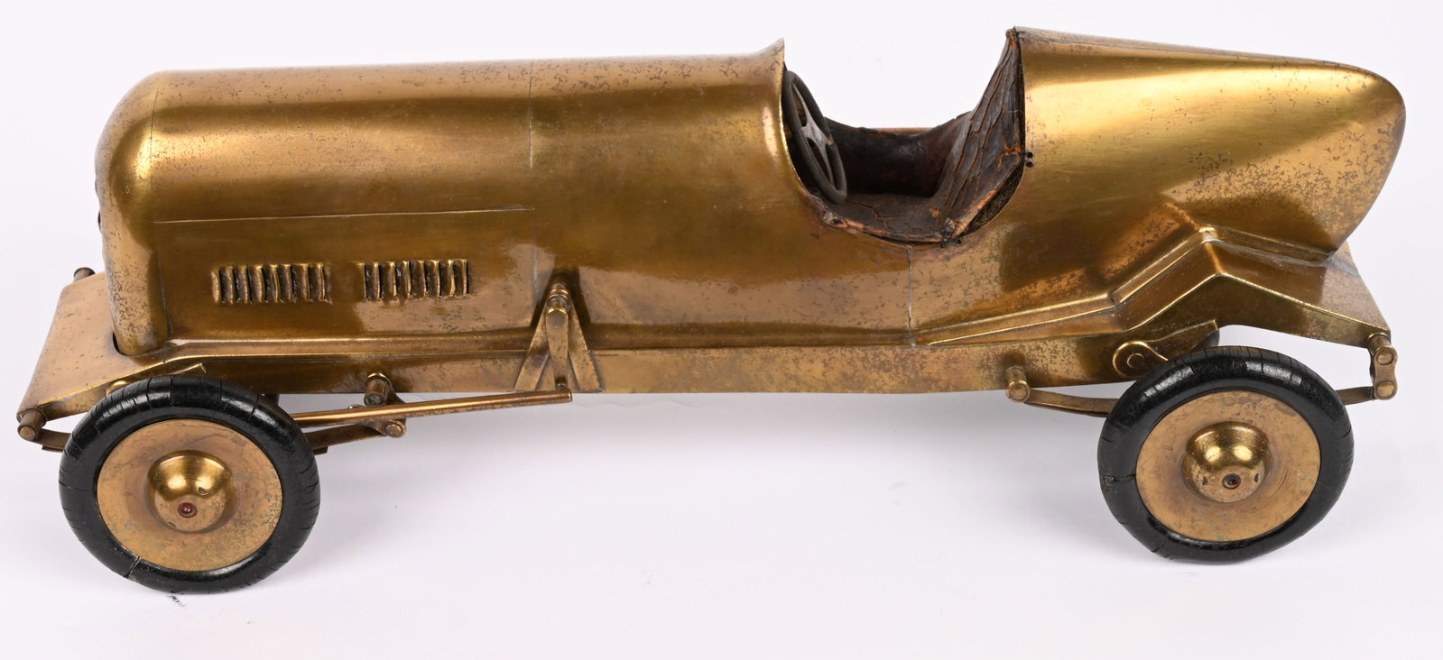 FOLK ART BRASS BOATTAIL RACE CAR: 1930s-40s Folk Art Brass BoatTail Race Car. All hand made and very well done with nice details. Still has original leather interior. Has leaf springs and front steering. A very rare and wonderful piec