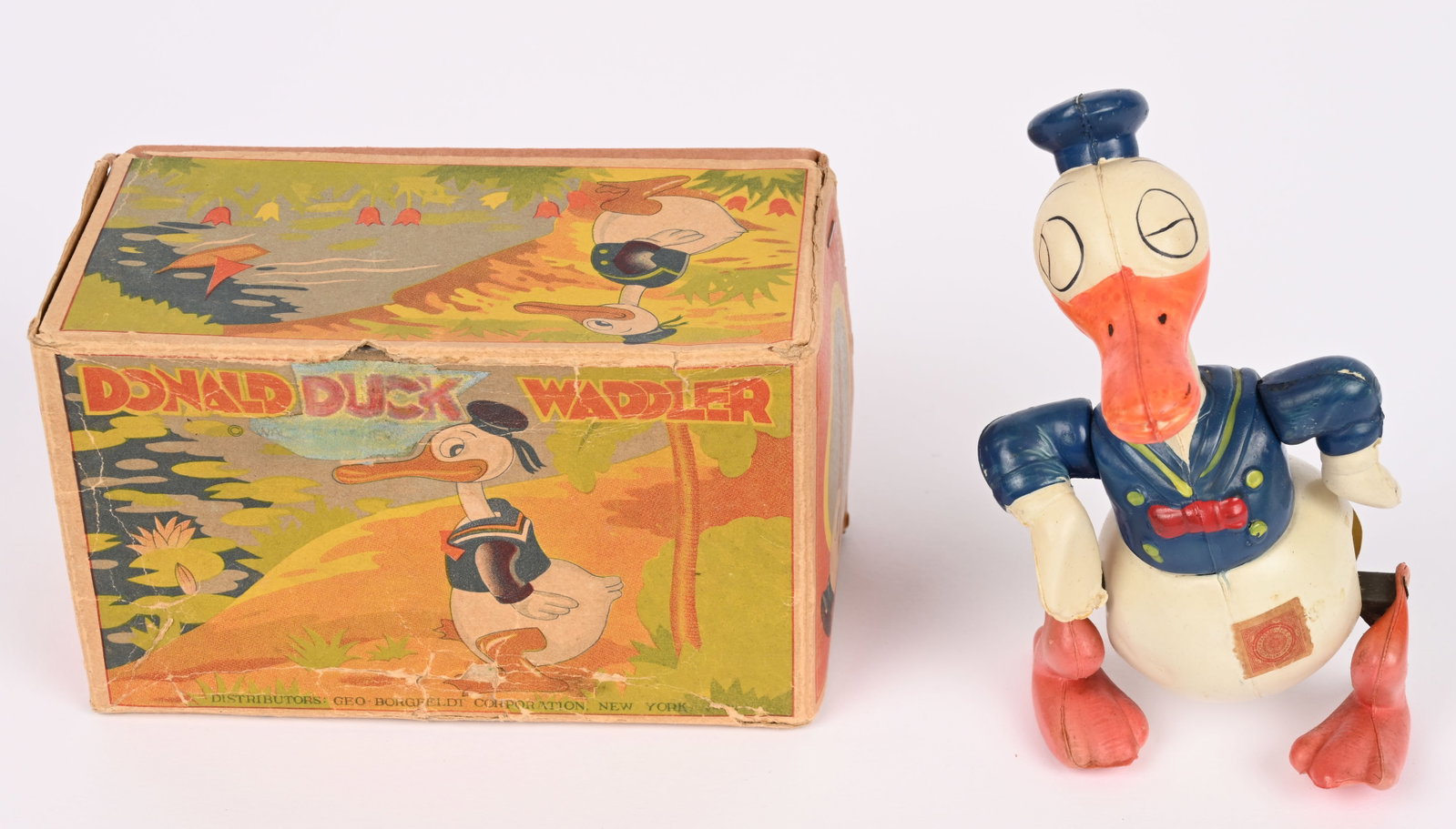JAPAN CELLULOID DONALD DUCK WADDLER w/ BOX: Prewar Japan celluloid windup Long Billed Donald Duck Waddler. All original in great condition. Has nice colors. Still has import sticker. Boxed 5 1/2" Excellent