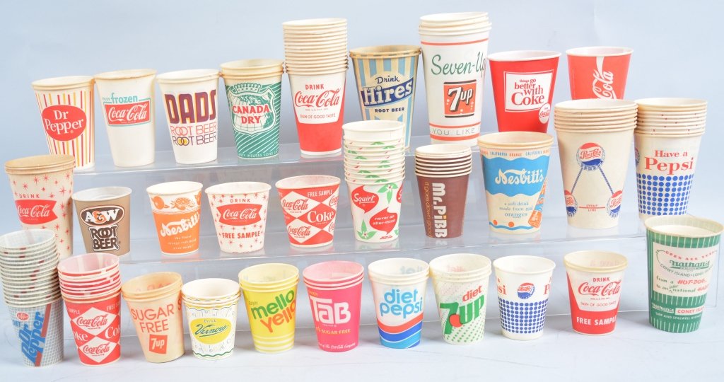 Vintage Coca Cola Lot: Includes 2- 1950s Coca Cola Appointment Books in Boxes, Coca Cola Placemats from Hawaii, Set of Coca Cola magazines and Bottler Books, and collection of Paper Cups. Excellent