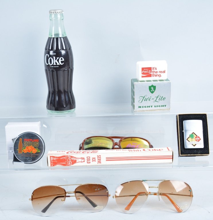 Lot of Coca Cola Zippo Lighters, Sun Glasses, and: Includes 2 Zippo Lighters in box, 3 pais of Coca Cola Sun Glasses, Coke Bottle Radio, and more. Excellent
